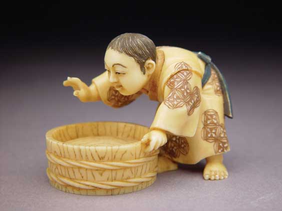 Appraisal: CARVED IVORY NETSUKE Carved ivory netsuke of a boy with