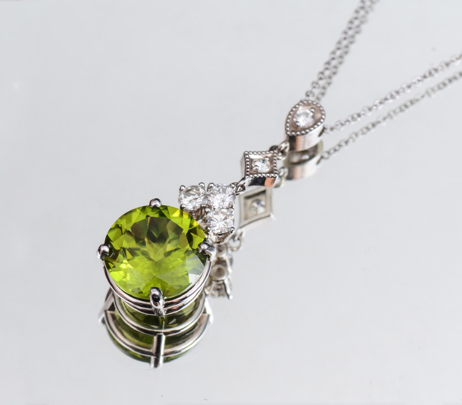 Appraisal: PERIDOT AND DIAMOND PENDANT NECKLACE k white gold pendant featuring