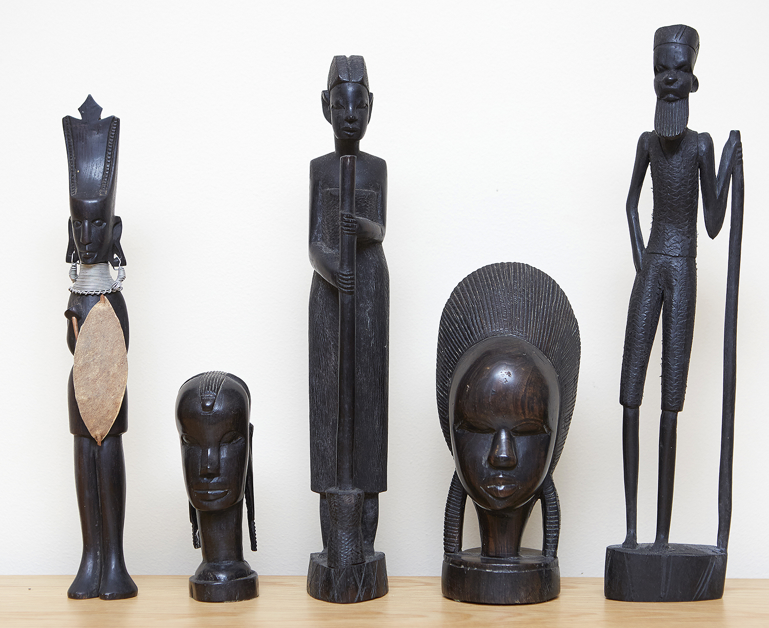 Appraisal: A GROUP OF FIVE AFRICAN CARVINGS Comprising two busts and