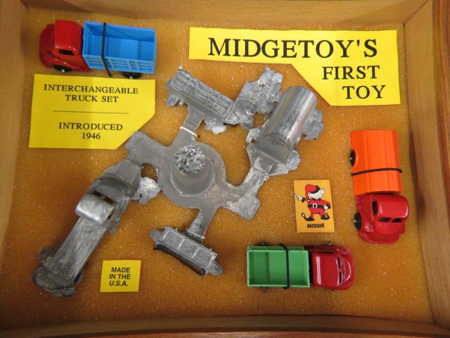 Appraisal: Midgetoy Metal Toy Trucks in display case with mold piece