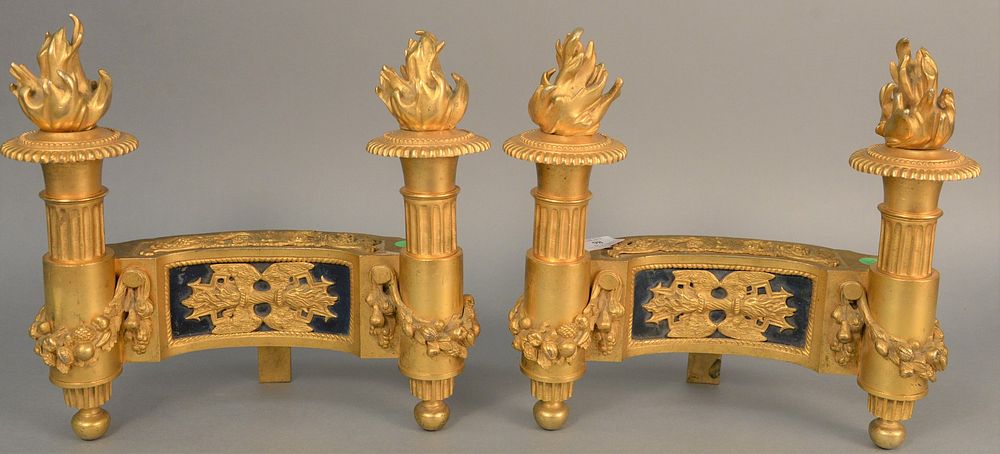 Appraisal: Pair of French bronze dore chenets having flaming torchiere ends