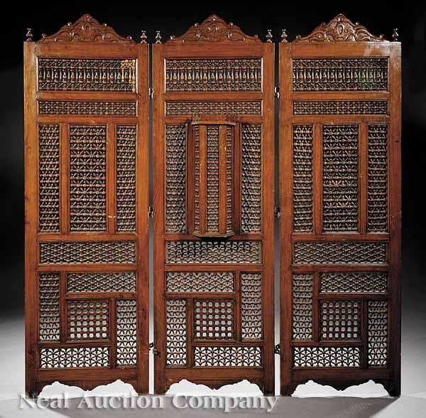 Appraisal: A Moroccan Carved Hardwood Screen three panels with scroll-carved crests