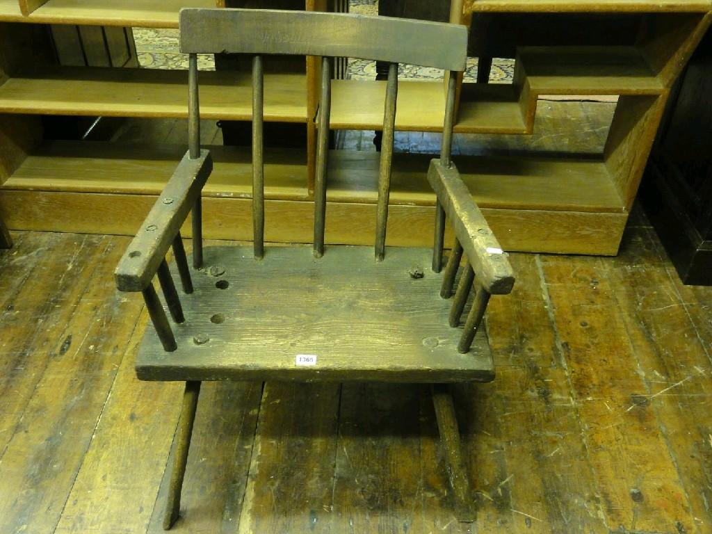 Appraisal: A primitive Windsor stick back elbow chair with solid seat