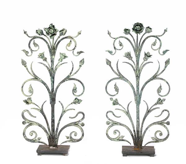 Appraisal: A pair of patinated wrought iron flori form andirons height