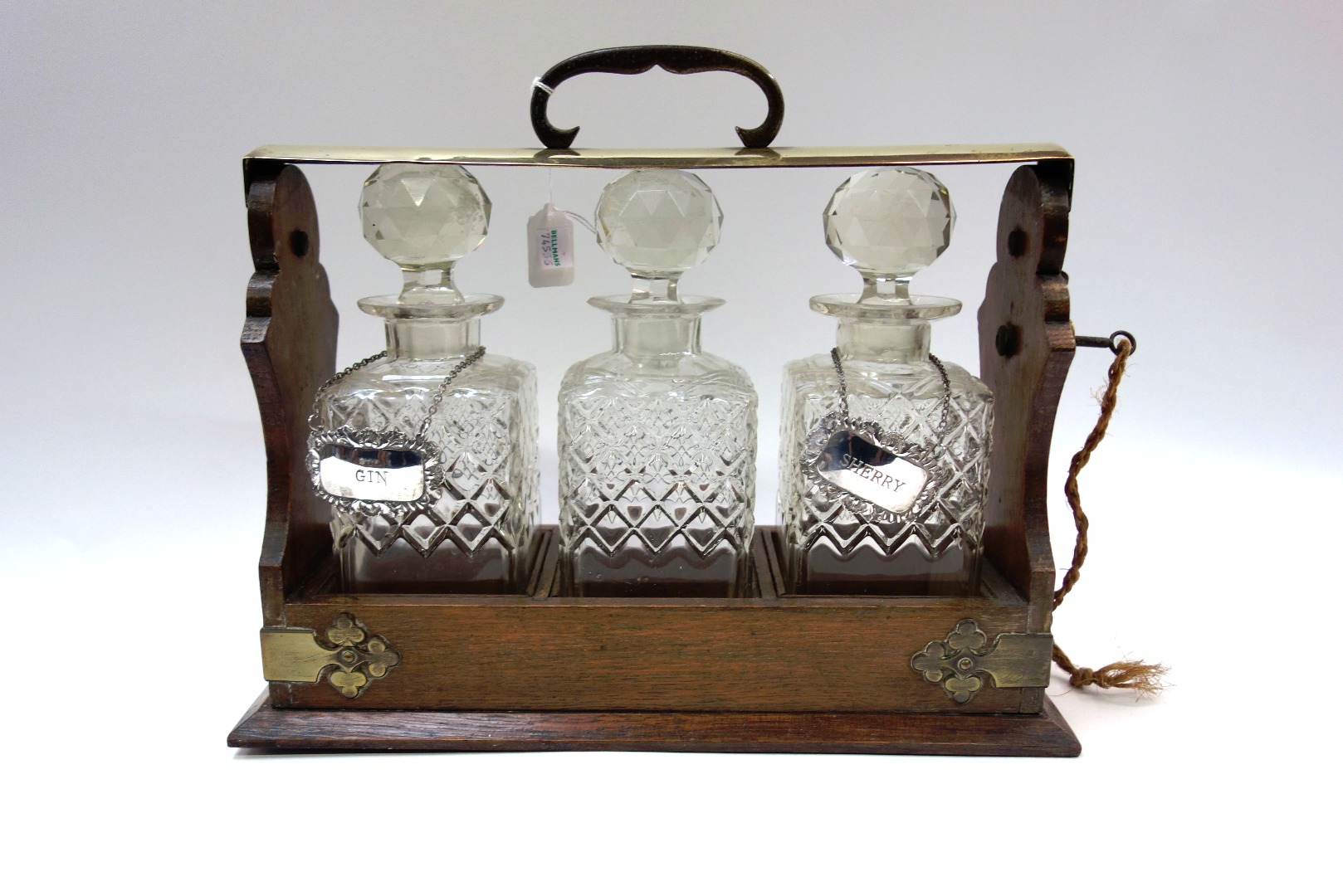 Appraisal: An Edwardian electroplate mounted oak tantalus with three moulded glass