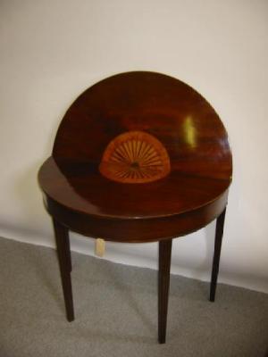 Appraisal: A MAHOGANY FOLDING TEA TABLE of demi lune form with