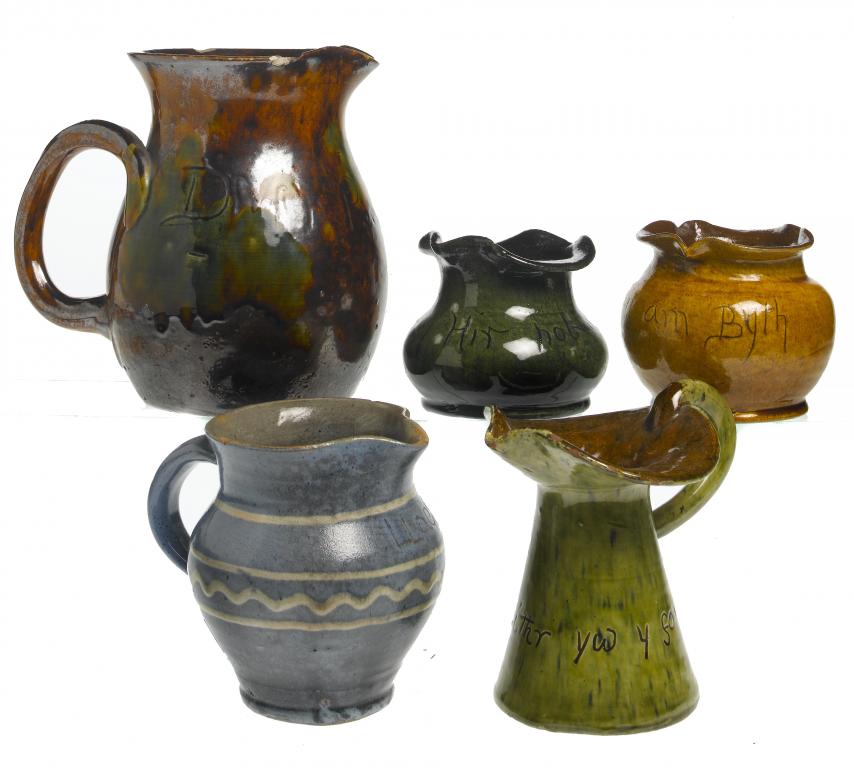 Appraisal: THREE EWENNY SLIPWARE JUGS AND TWO VASES covered in yellow