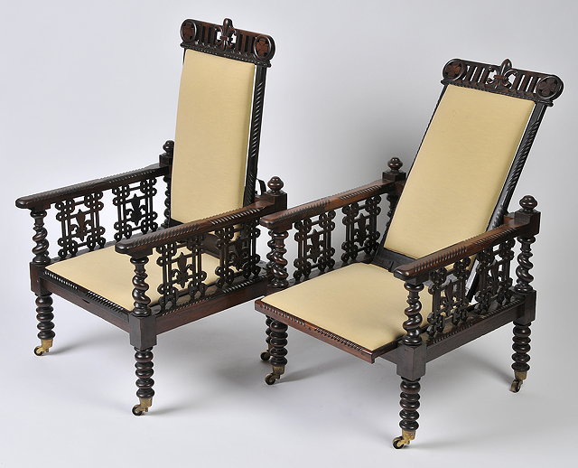 Appraisal: A PAIR OF ROSEWOOD COLONIAL RECLINING ARMCHAIRS with carved fretwork