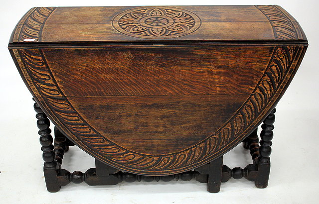 Appraisal: AN OAK GATELEG TABLE with chip carved top and turned