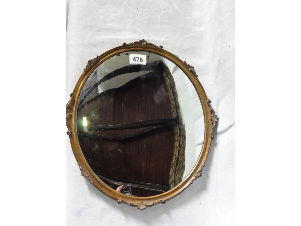 Appraisal: A small slightly convex oval wall mirror within a slim