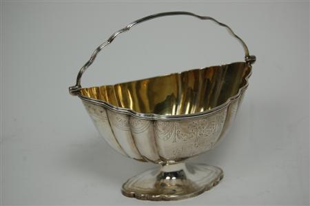 Appraisal: A George III swing handled sugar basket London the shaped