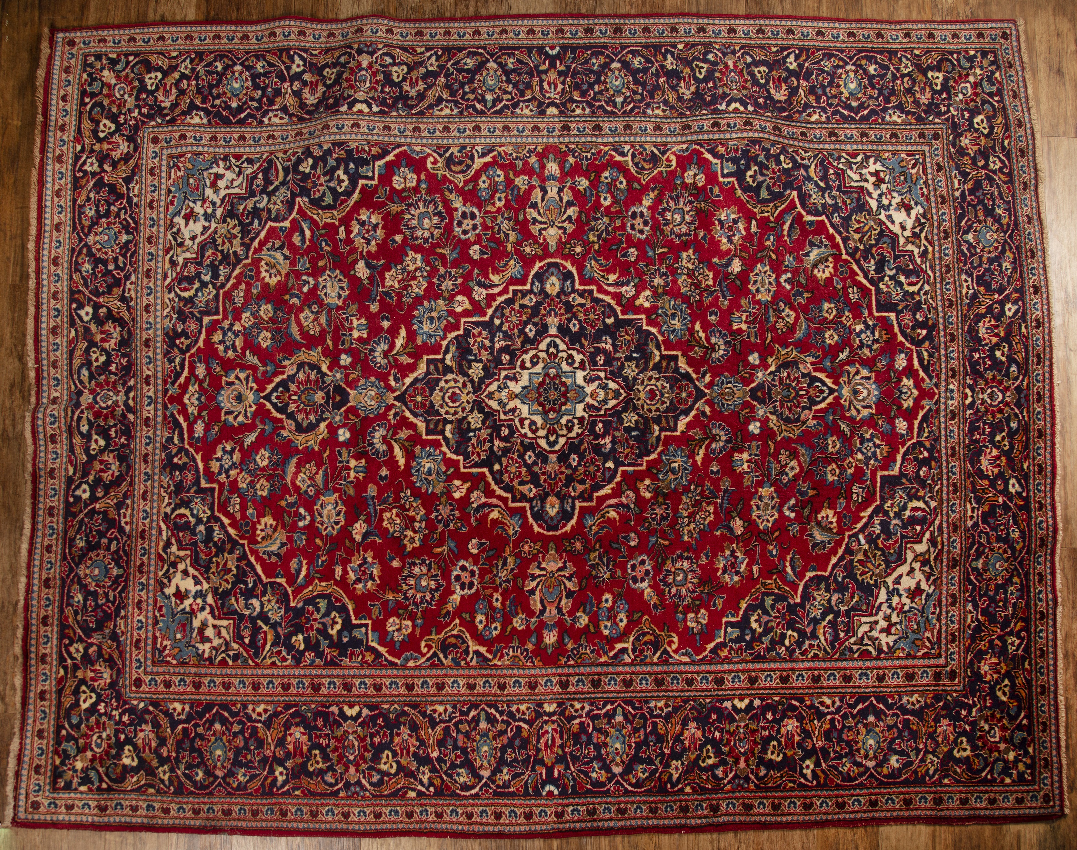 Appraisal: Ardekan red and blue ground wool carpetIranian with floral and