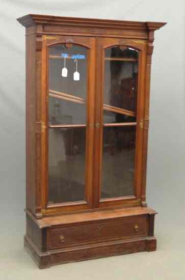 Appraisal: Victorian walnut two door single drawer Eastlake bookcase on stand