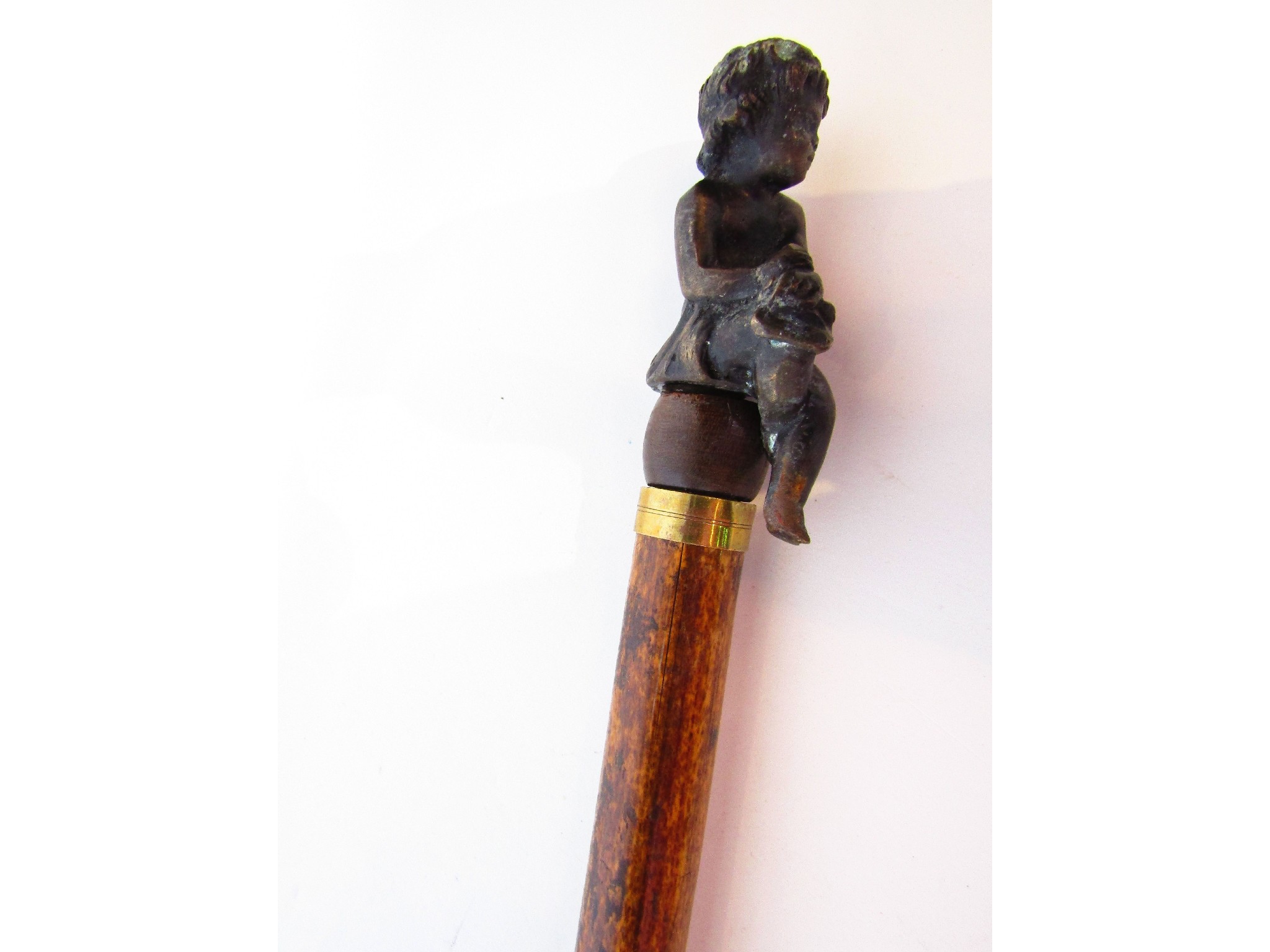 Appraisal: A bamboo walking cane terminating in an applied cast metal