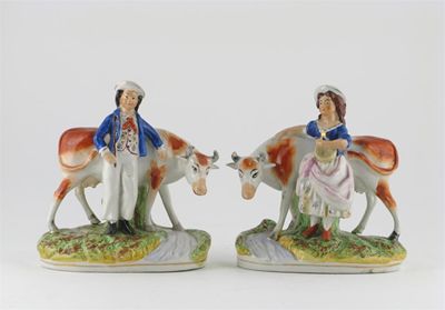 Appraisal: A pair of Staffordshire models of cows with a milkmaid