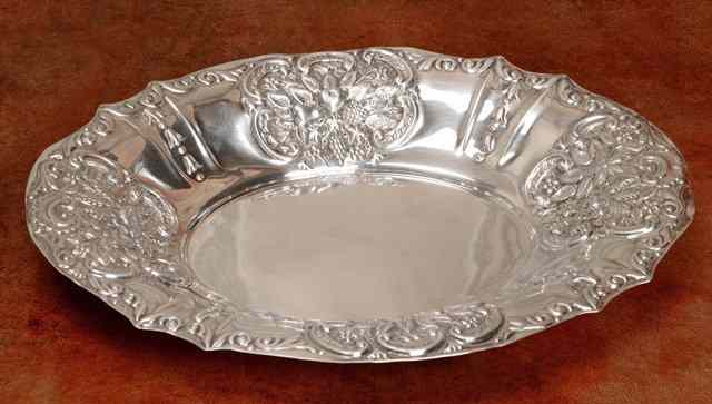 Appraisal: AN OVAL SILVER DISH with pressed panels of fruit and