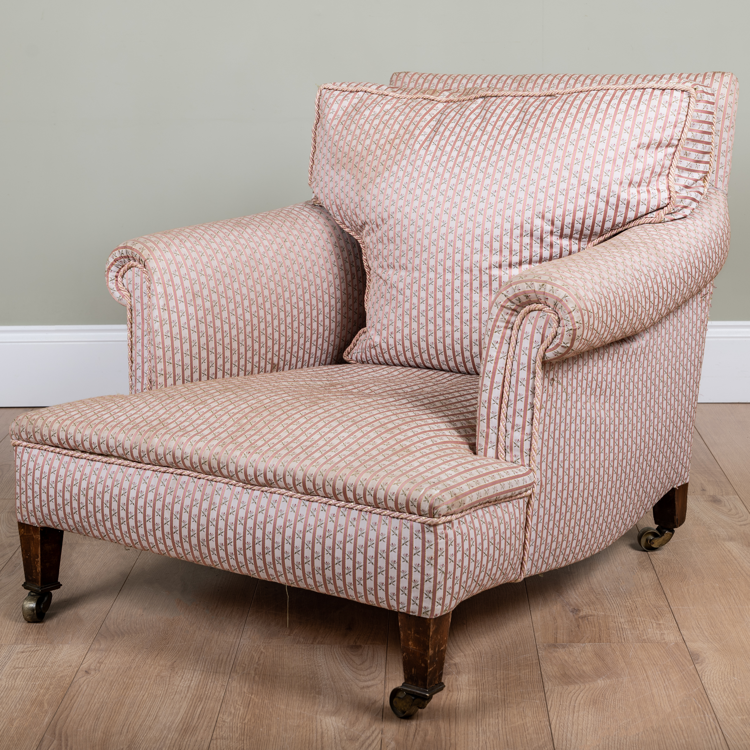 Appraisal: A low deep Howard style armchair with scrolling arms square