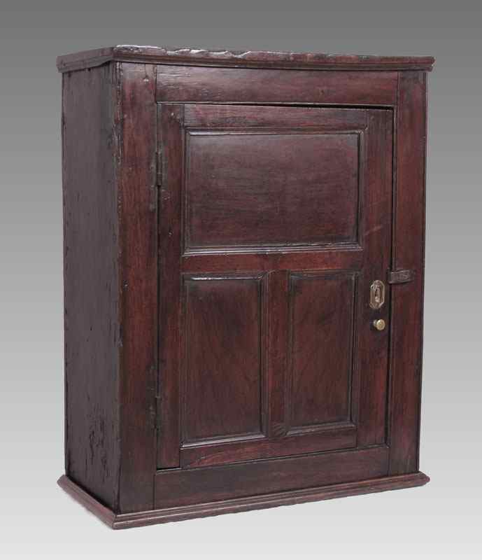 Appraisal: TH C SINGLE DOOR ENGLISH WALNUT HANGING CUPBOARD Three recessed