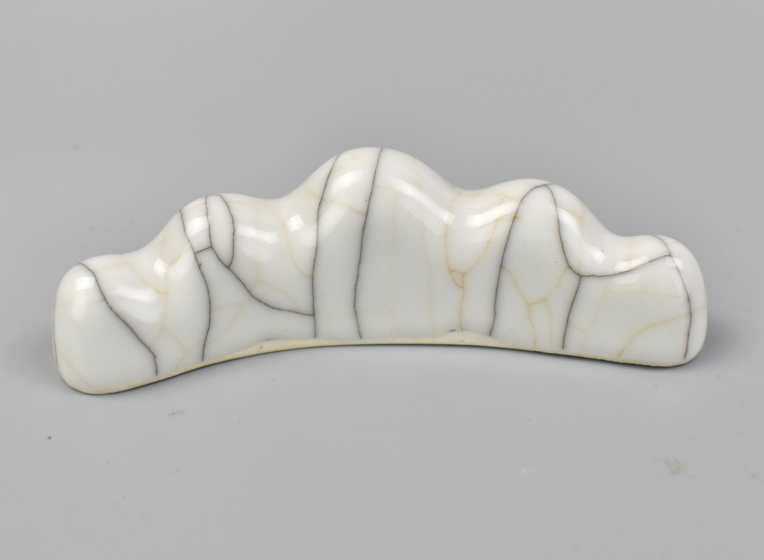 Appraisal: A Chinese ge glazed curved pottery brush holder suggesting undulating