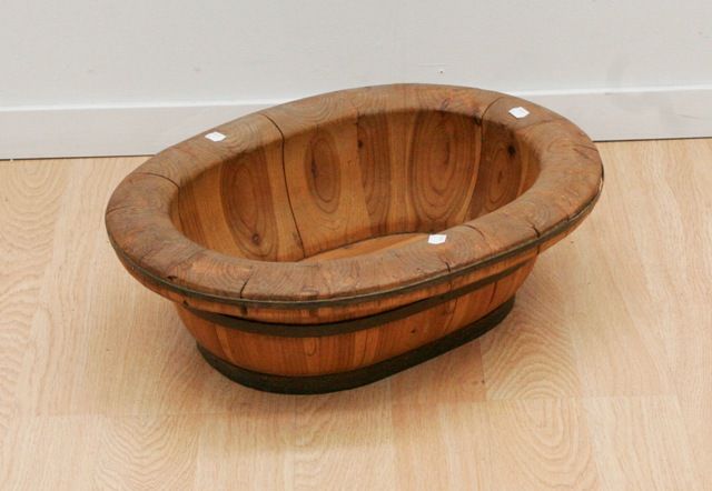 Appraisal: A Chinese oval iron bound bowl constructed of tapering wood