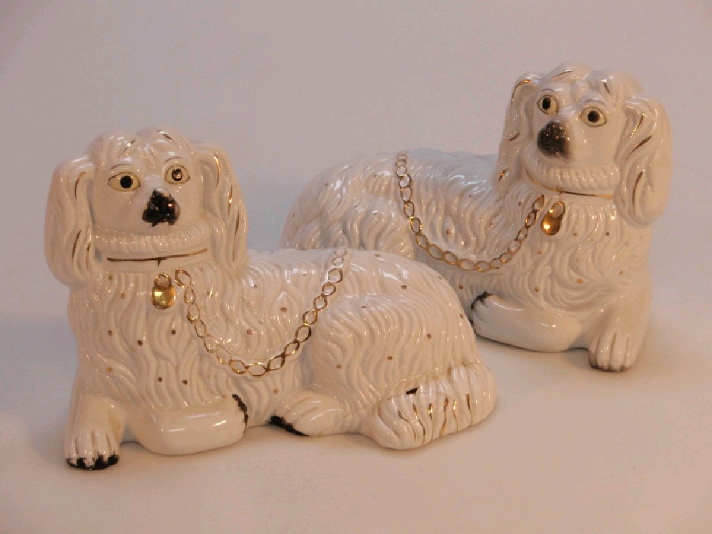 Appraisal: A pair of Staffordshire type recumbent Spaniels with gilt collars