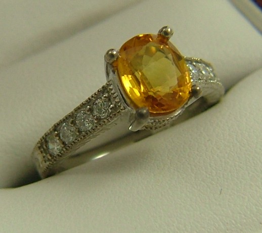 Appraisal: ORANGE SAPPHIRE DIAMOND AND FOURTEEN KARAT GOLD RING centering an