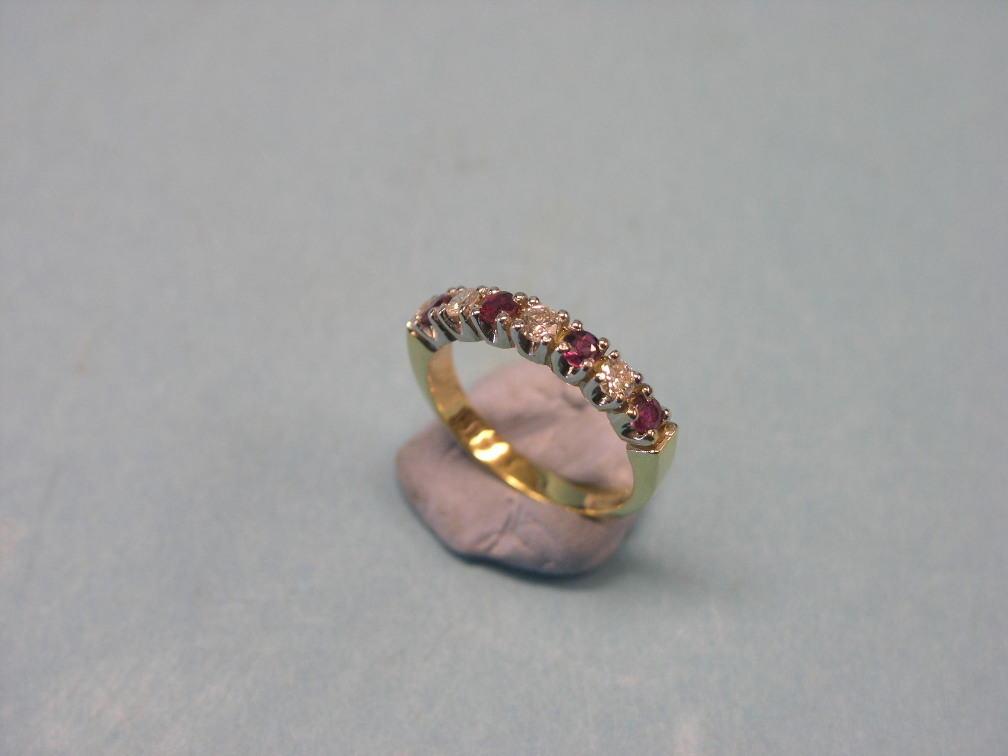 Appraisal: An ct gold diamond and ruby half-eternity ring three diamonds