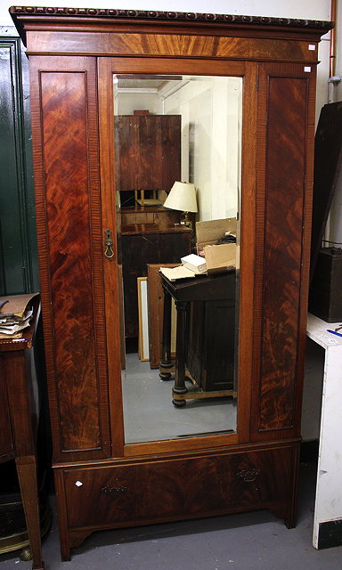 Appraisal: A MAHOGANY WARDROBE with single mirrored door over a single