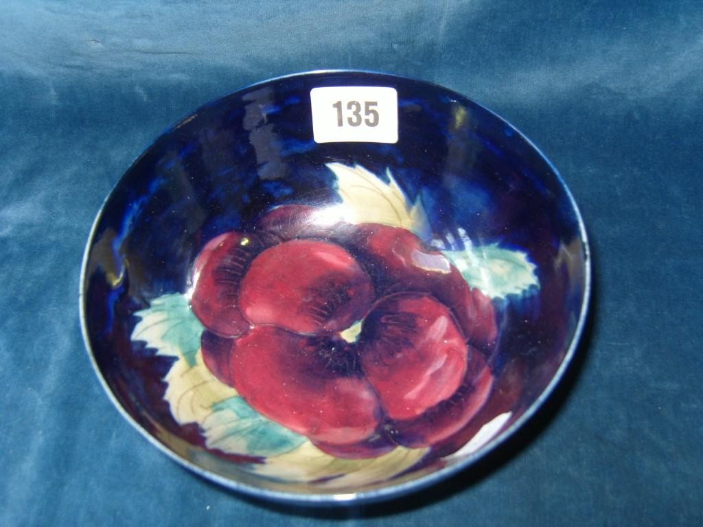 Appraisal: A blue ground Moorcroft bowl with painted pansy decoration to