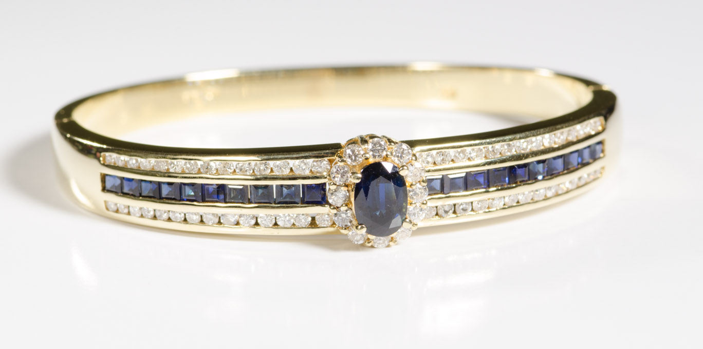 Appraisal: SAPPHIRE DIAMOND AND FOURTEEN KARAT GOLD BANGLE with table-cut sapphires