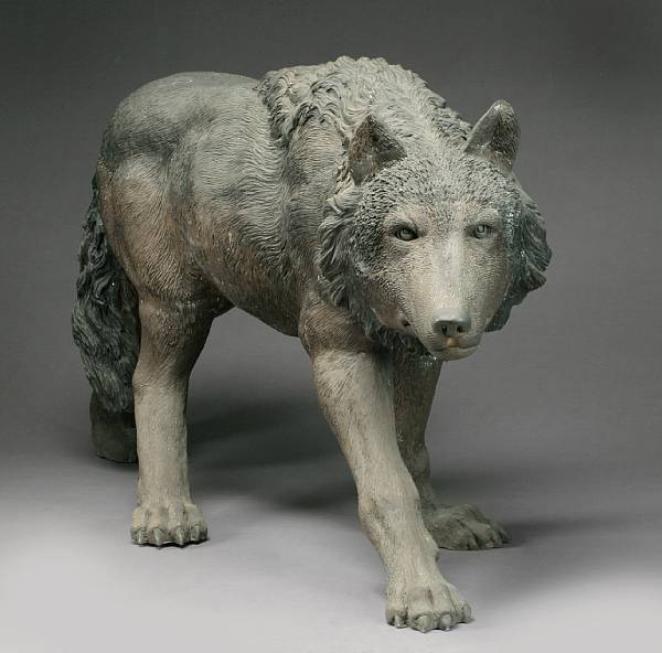 Appraisal: A patinated bronze study of a wolf Depicted in submissive