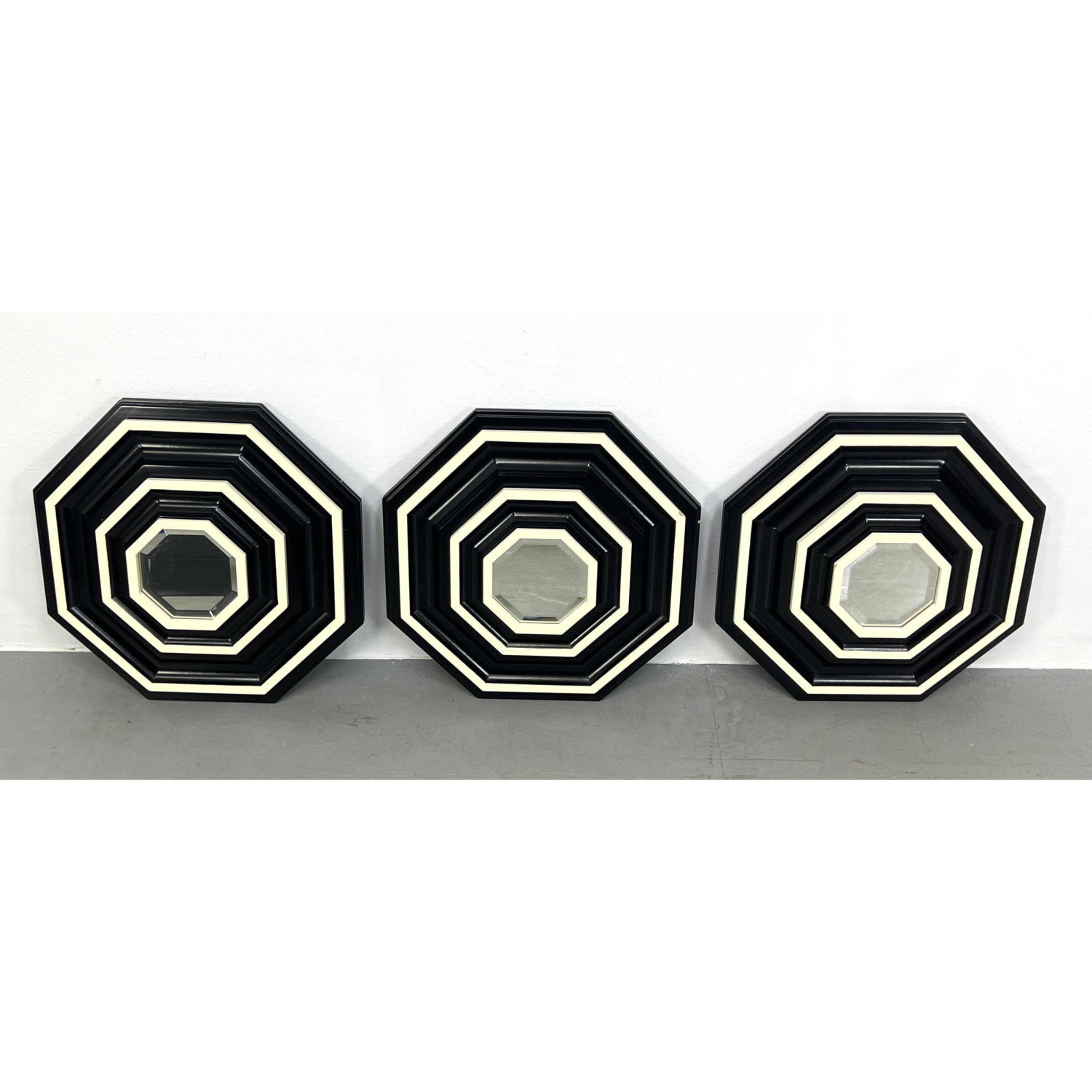 Appraisal: Collection of Black And Cream Octagonal Mirrors Graphic layered stepped