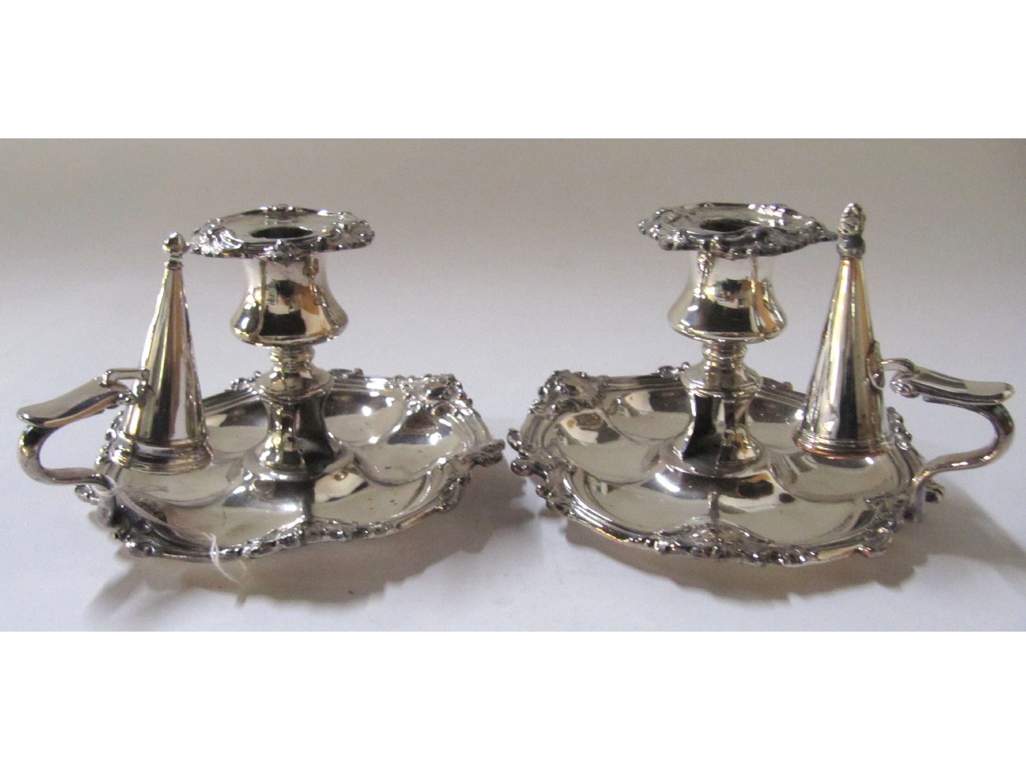 Appraisal: A pair of silver plated chambersticks