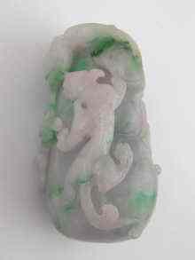 Appraisal: A Chinese jade pendant heavily carved with a mythical animal