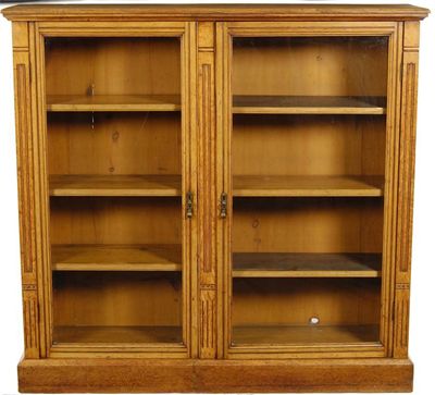 Appraisal: An oak bookcase with a pair of glazed doors enclosing