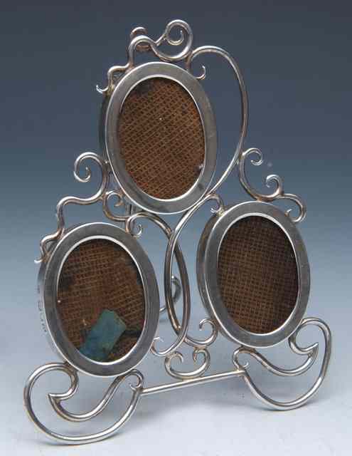 Appraisal: A LATE VICTORIAN SILVER TRIPLE PHOTOGRAPH FRAME the oval frames