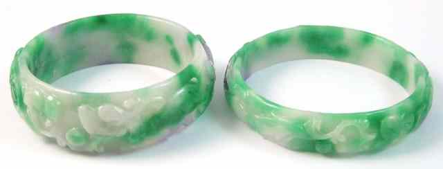 Appraisal: TWO CARVED JADE BANGLES Both round bangles are green white