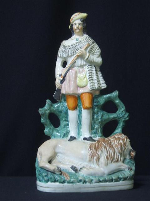 Appraisal: STAFFORDSHIRE FIGURE OF GEORGE CUMMING AND LION Circa the standing