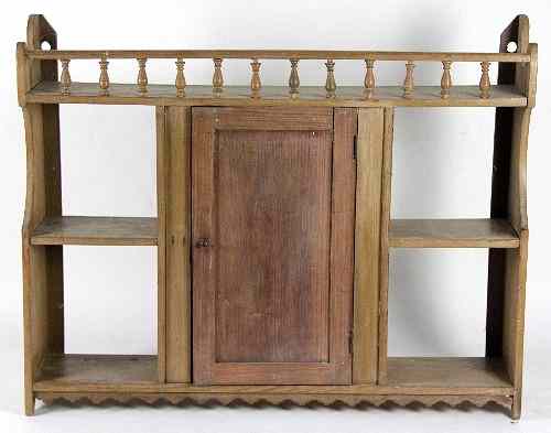 Appraisal: A pine hanging cupboard with galleried top enclosed by a