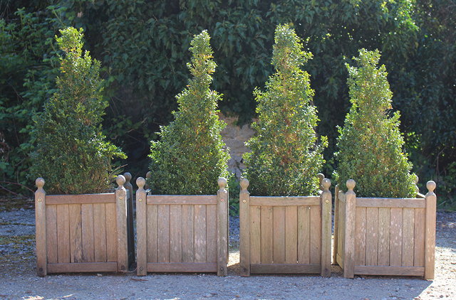 Appraisal: A SET OF FOUR TEAK WOODEN PLANTERS each with ball