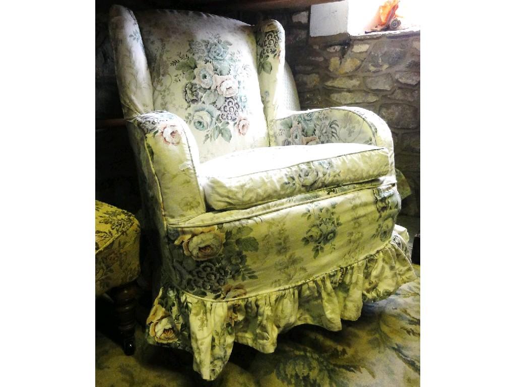 Appraisal: A wing back armchair with loose floral cover raised on