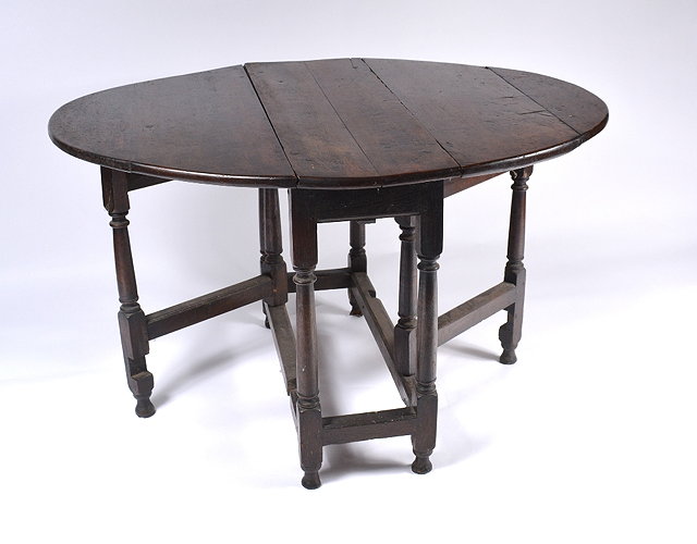 Appraisal: An th Century oak oval drop leaf dining tablewith gate-leg