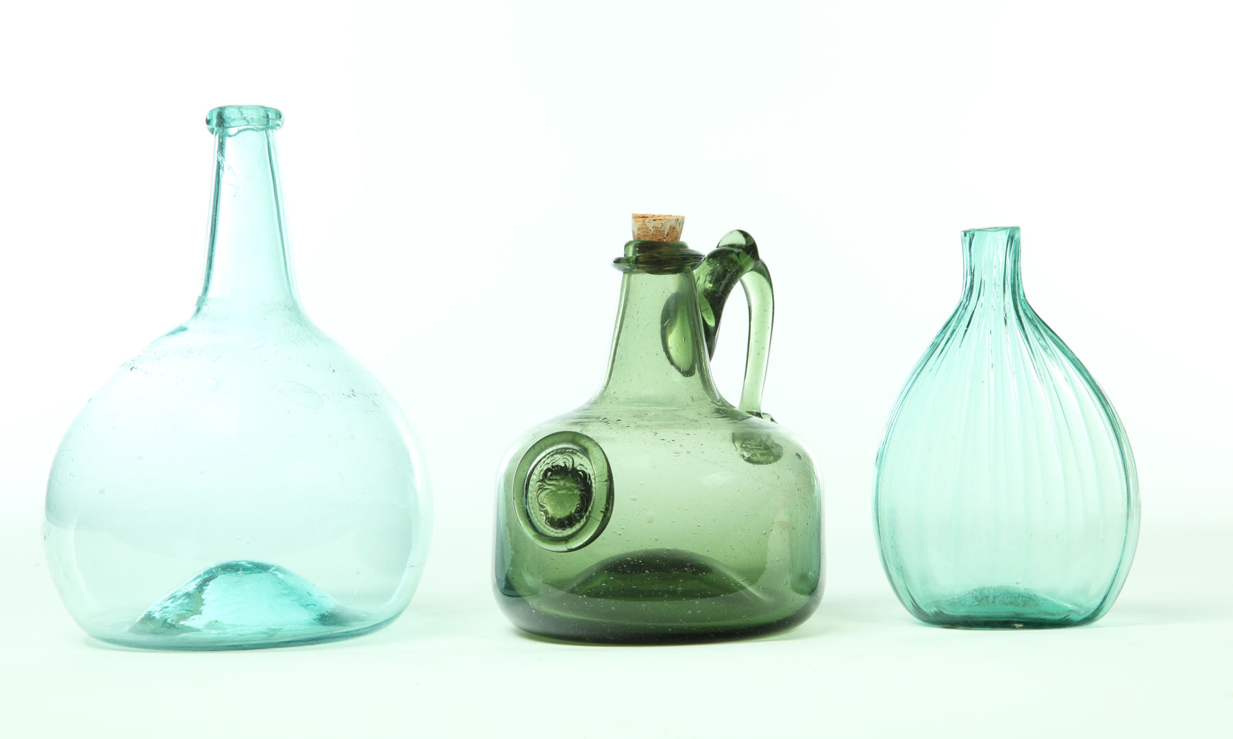 Appraisal: THREE BLOWN GLASS BOTTLES Nineteenth century Two American aqua bottles