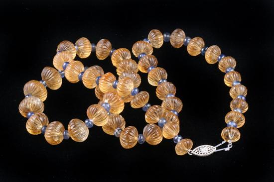 Appraisal: CARVED CITRINE AND SAPPHIRE BEAD NECKLACE graduated rib-carved bun-shaped golden