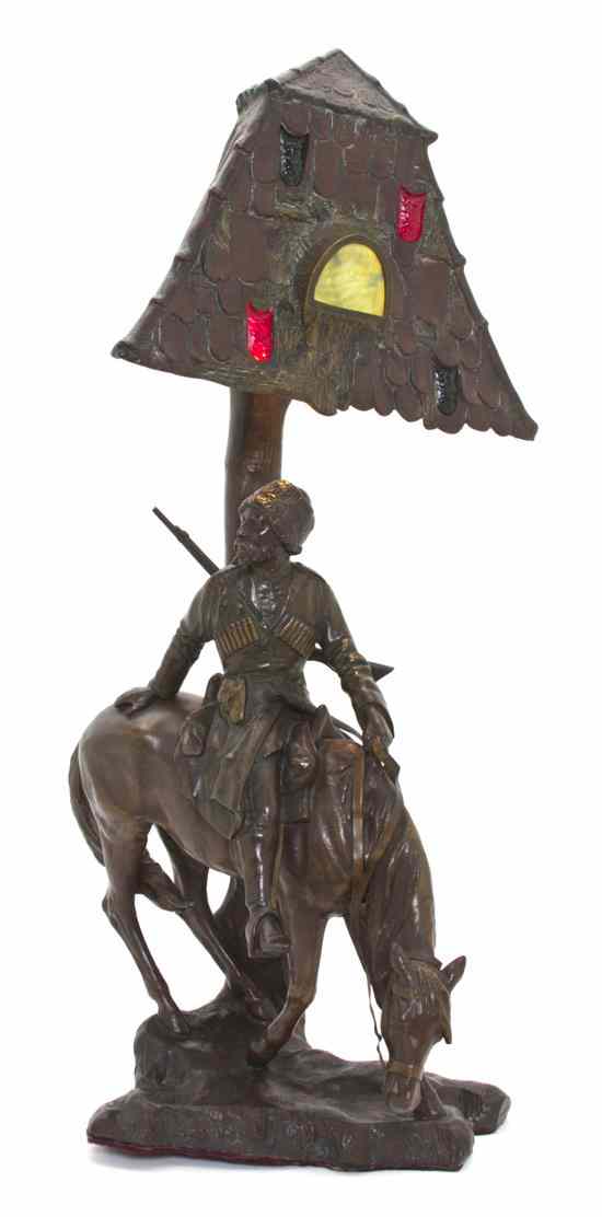 Appraisal: A German Bronzed Metal Figural Lamp the roof form shade