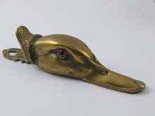 Appraisal: A cast brass duck's head paper clip with glass eyes