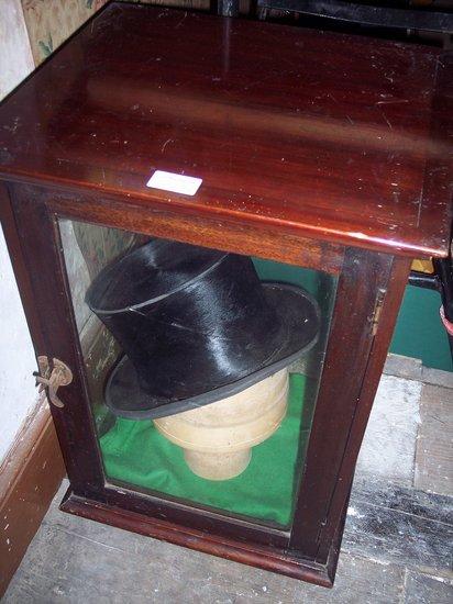 Appraisal: A glass display case cm wide containing a wooden hat