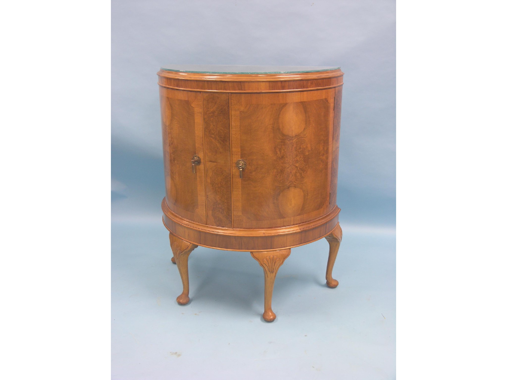 Appraisal: A burr walnut veneered drinks cabinet half-round single plate glass