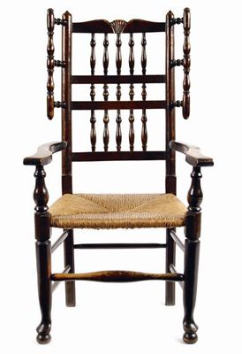 Appraisal: A Lancashire ash spindle back open armchair with a carved