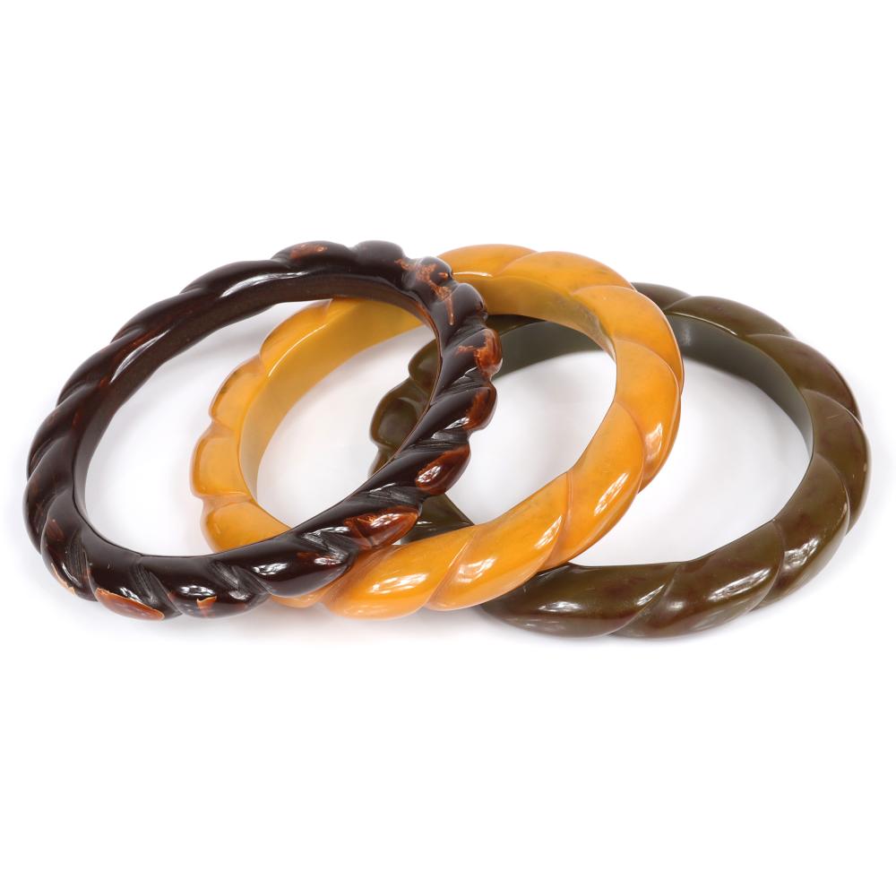 Appraisal: THREE BAKELITE BANGLE BRACELETS WITH CARVED SWIRL TWIST DESIGN IN